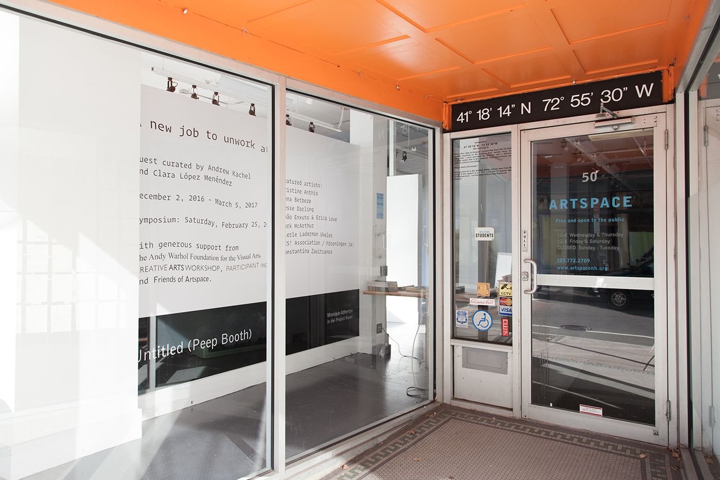 Artspace entrance, showing A new job to unwork at gallery wall graphic through the window. The graphic is simple, black and white text set in Operator, a typewriter font, subtly warped and distorted.
