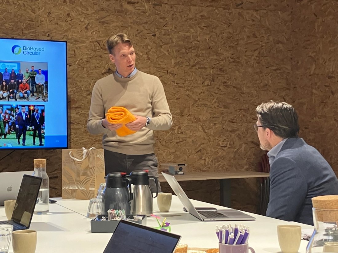 Gerard Nijhoving talks to Prince Constantin of the Netherlands holding orange BioFur prototype scarves.