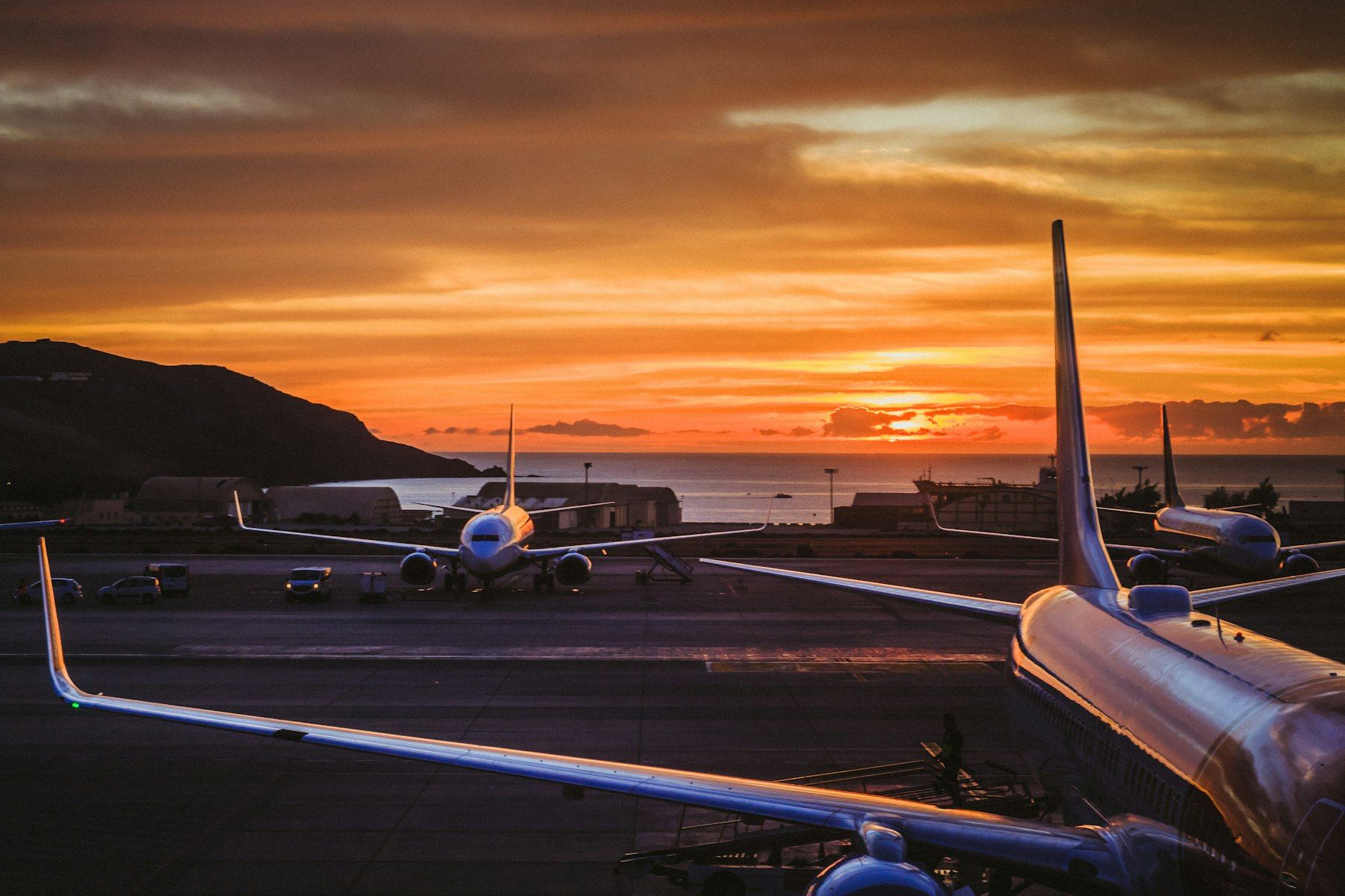 Apron at sunset with silhouetted airliners parked at their stands
