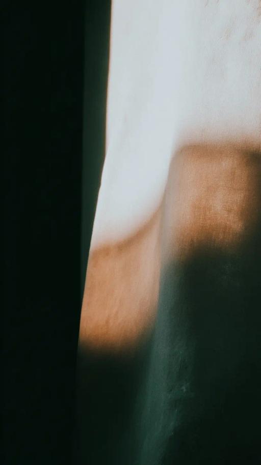 Juego de sombras de luz natural sobre una pared con colores claros y oscuros.