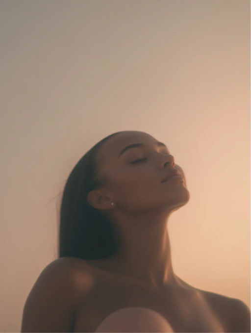 Mujer con ojos cerrados y expresión serena mirando hacia arriba con luz suave al atardecer.