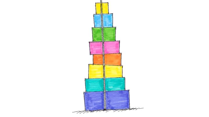 A tall stack of colorful blocks held upright by a single vertical spine running up through their centers.