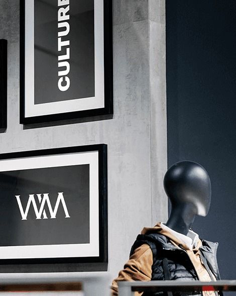 Framed Culture and monogram posters beside a mannequin