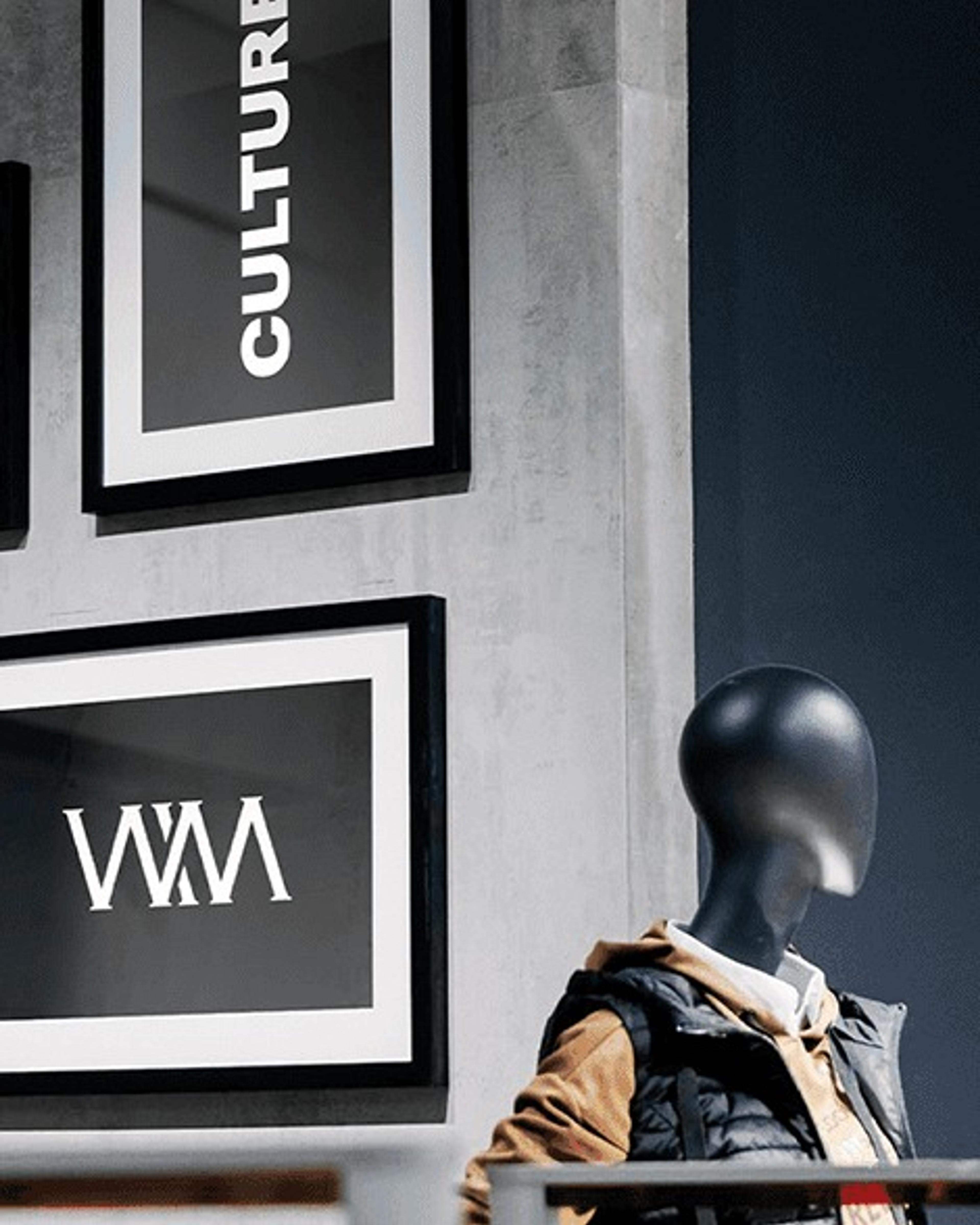 Framed Culture and monogram posters beside a mannequin