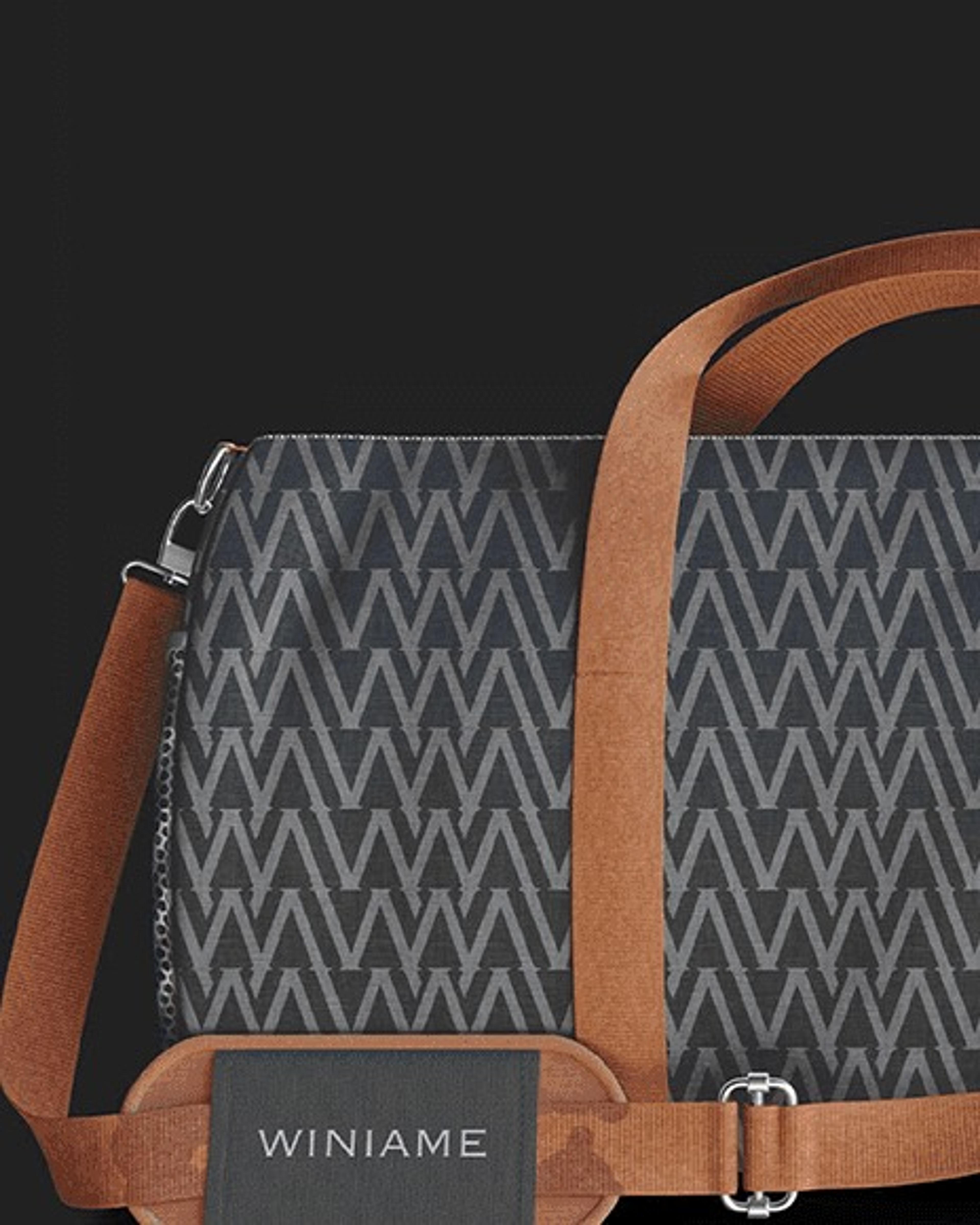 Patterned duffle bag with a tan strap and Winiame tag