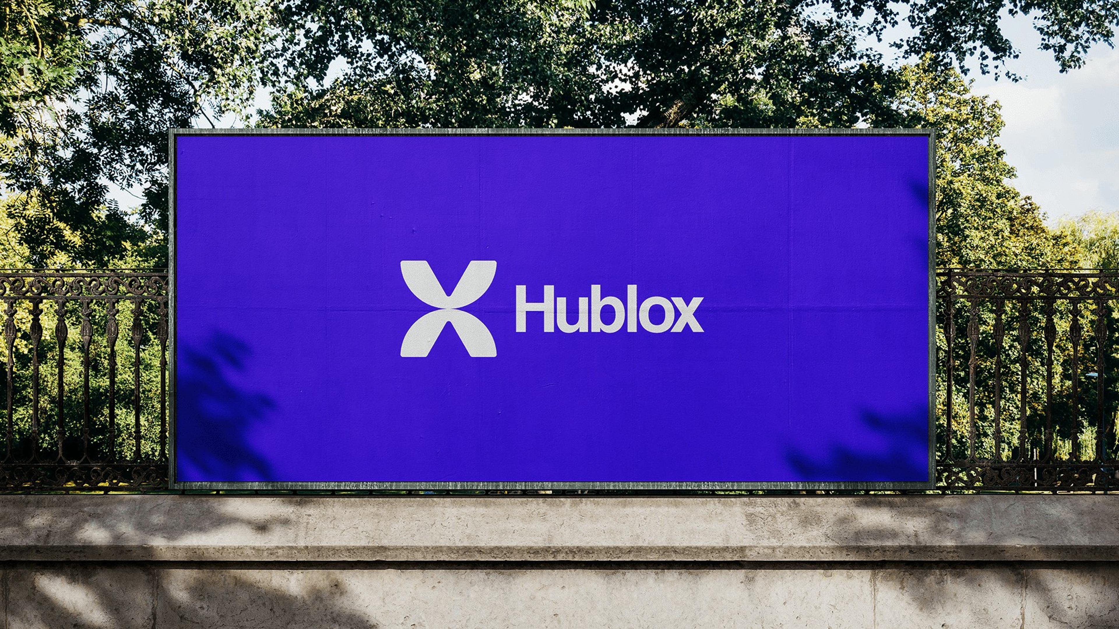 Hublox logo on a violet billboard in a park
