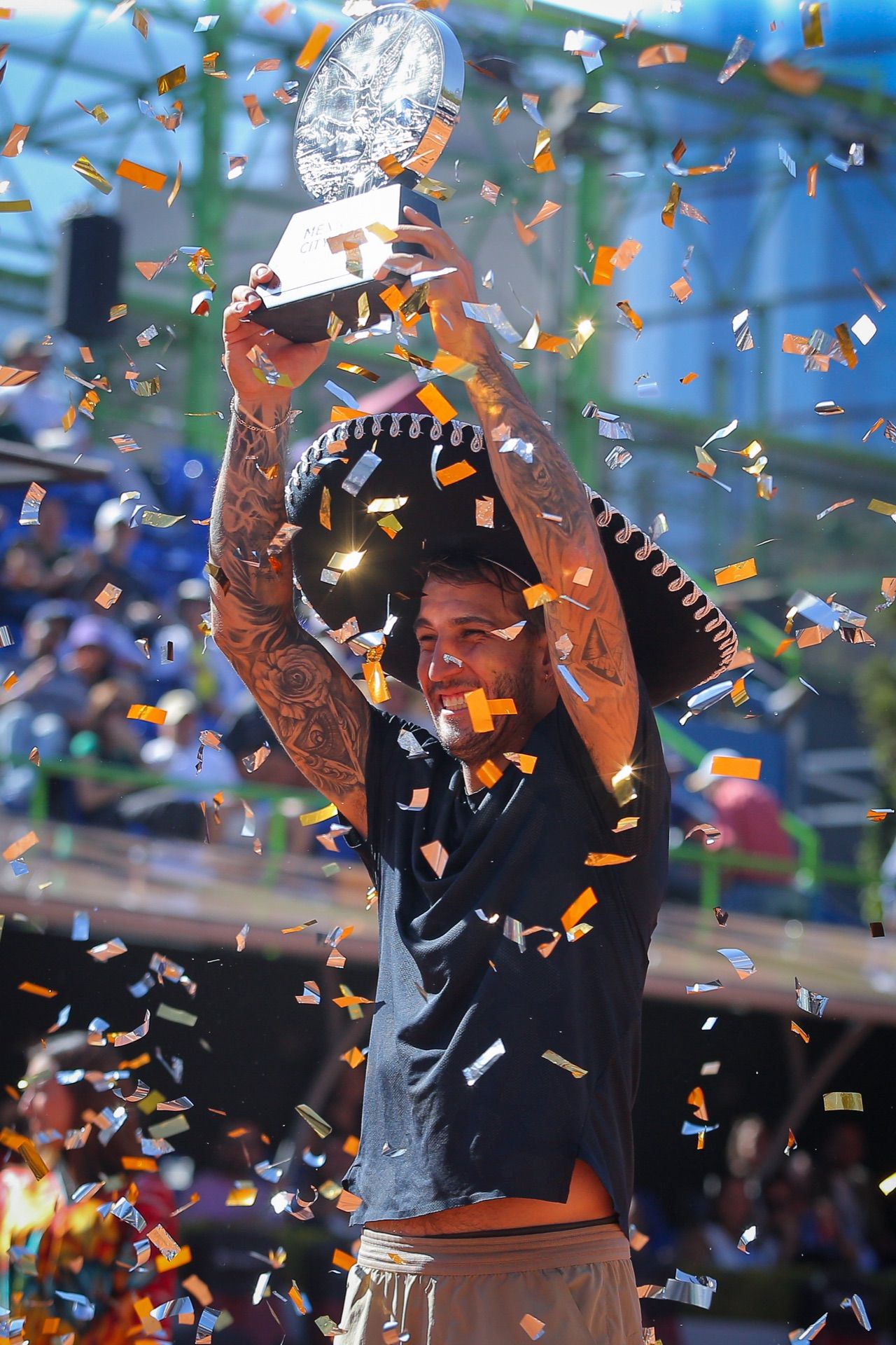El campeón levanta el trofeo con sombrero de charro bajo una lluvia de confeti.