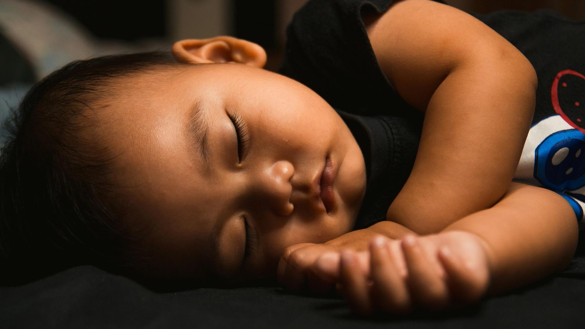 A baby is sleeping on a bed