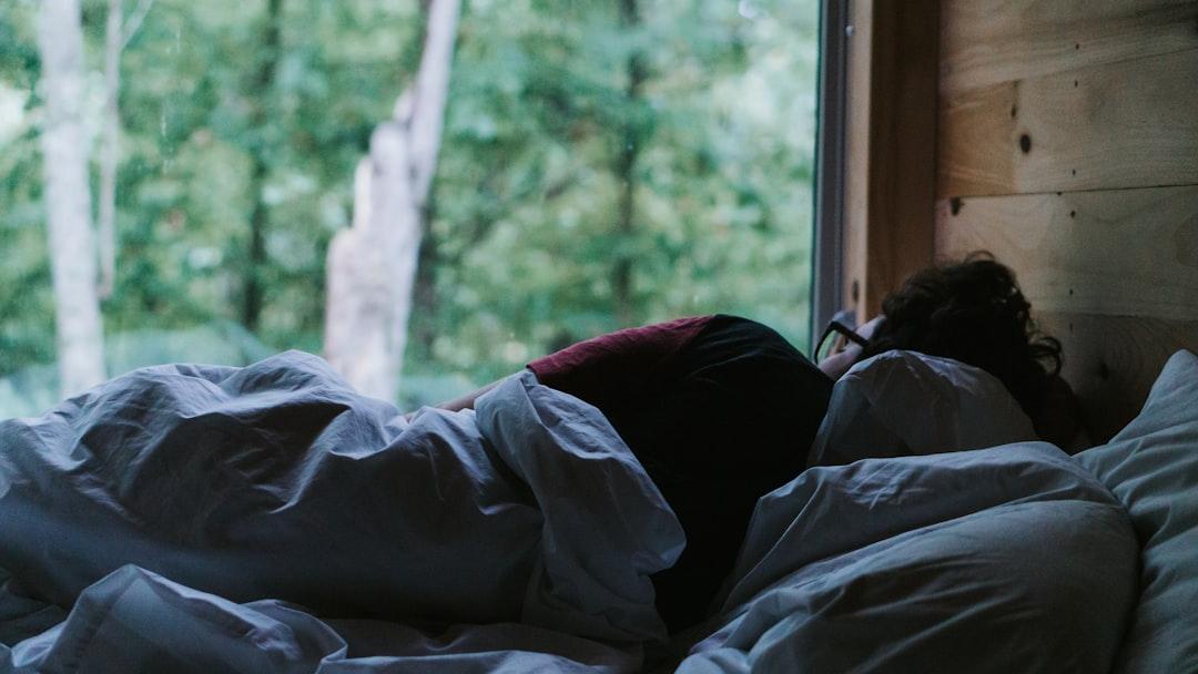 person lying on bed covered with blanket - Photo by Tatiana Rodriguez on Unsplash
