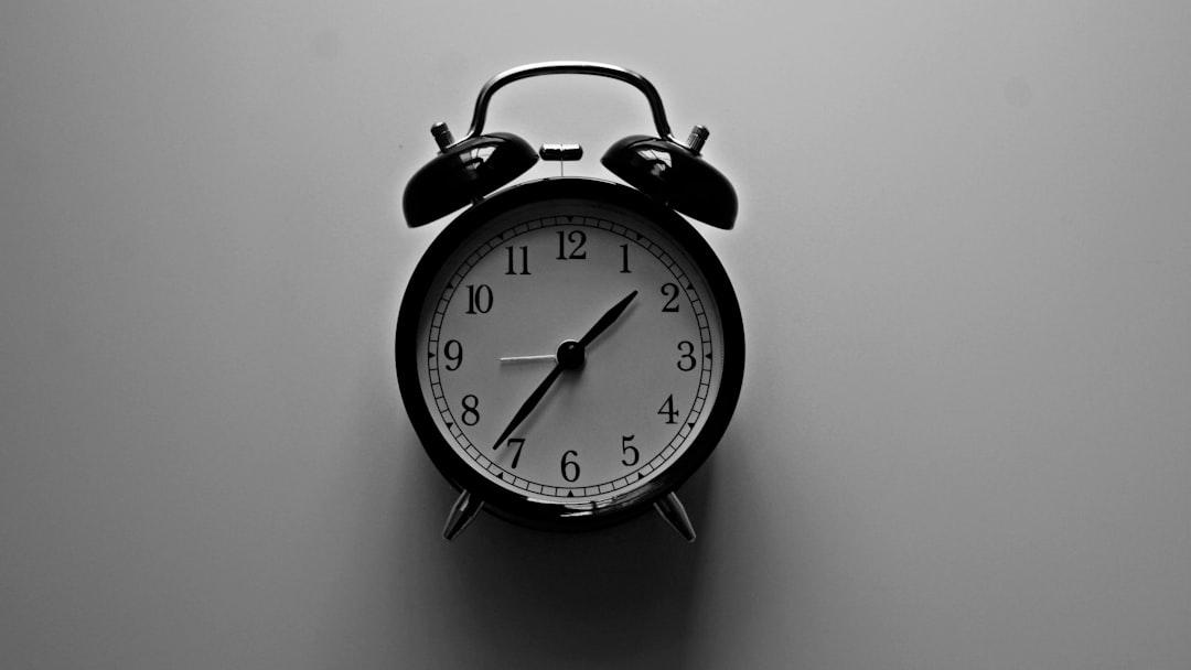 white bell alarm clock with black frame - Photo by Amanda Jones on Unsplash