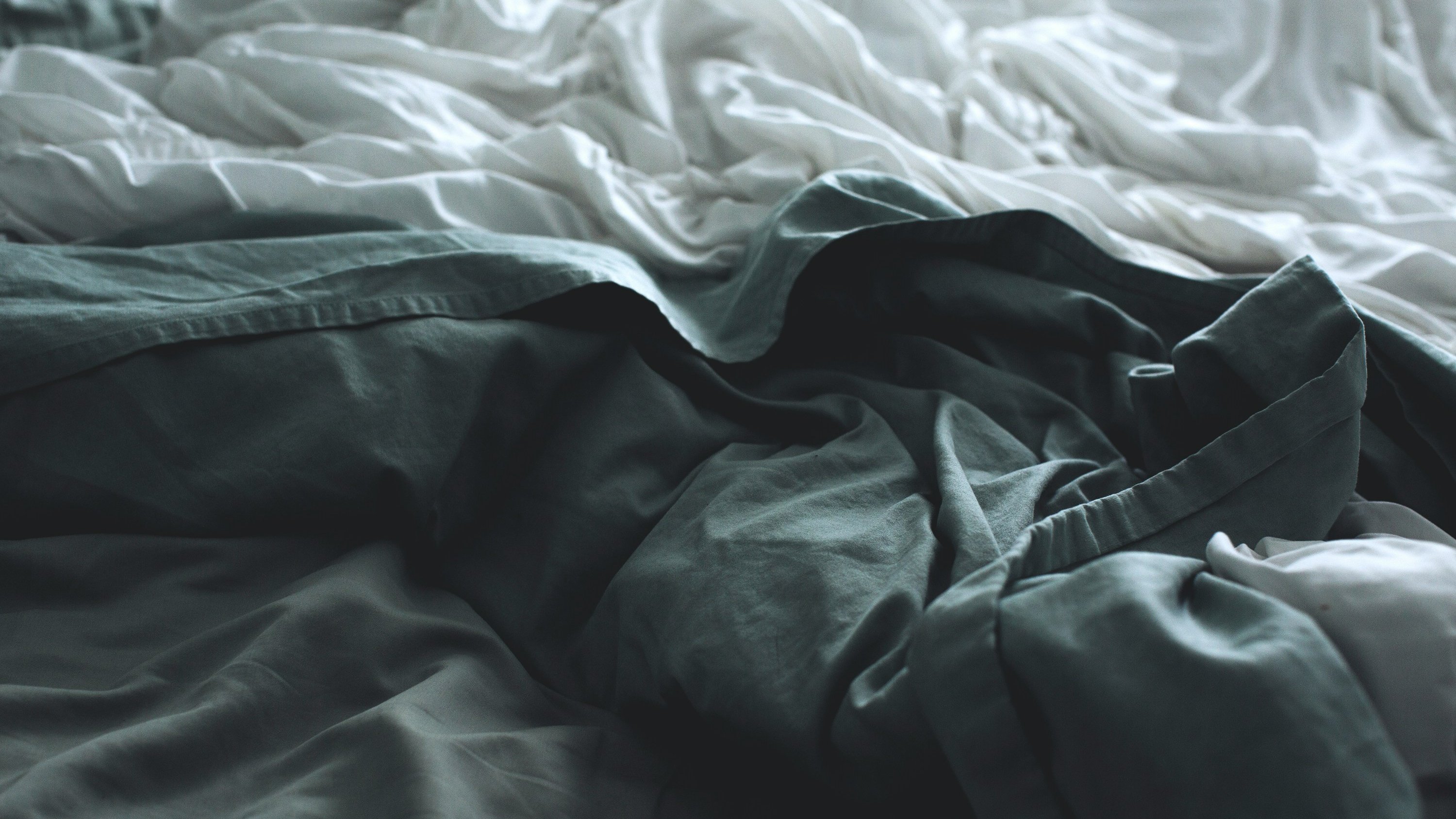 a bed with a lot of blankets and sheets on it .