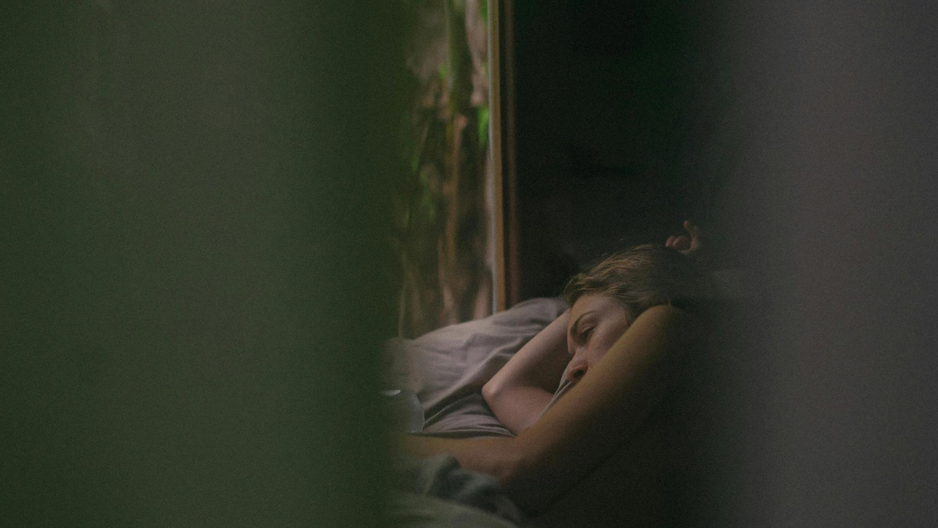 a woman is sleeping on a bed in front of a window