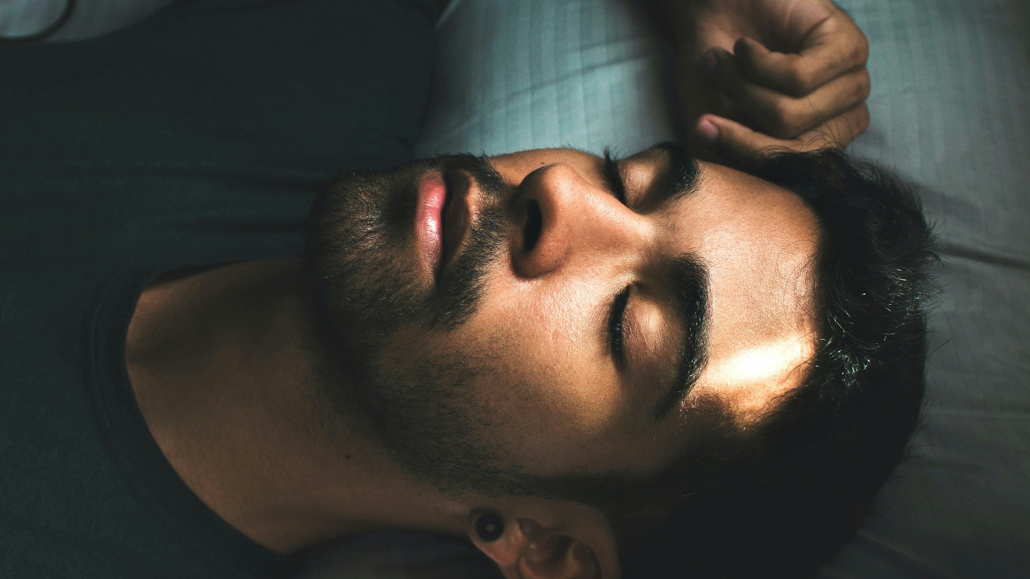 a man is sleeping on a bed next to a book that says " how to be a gecko "