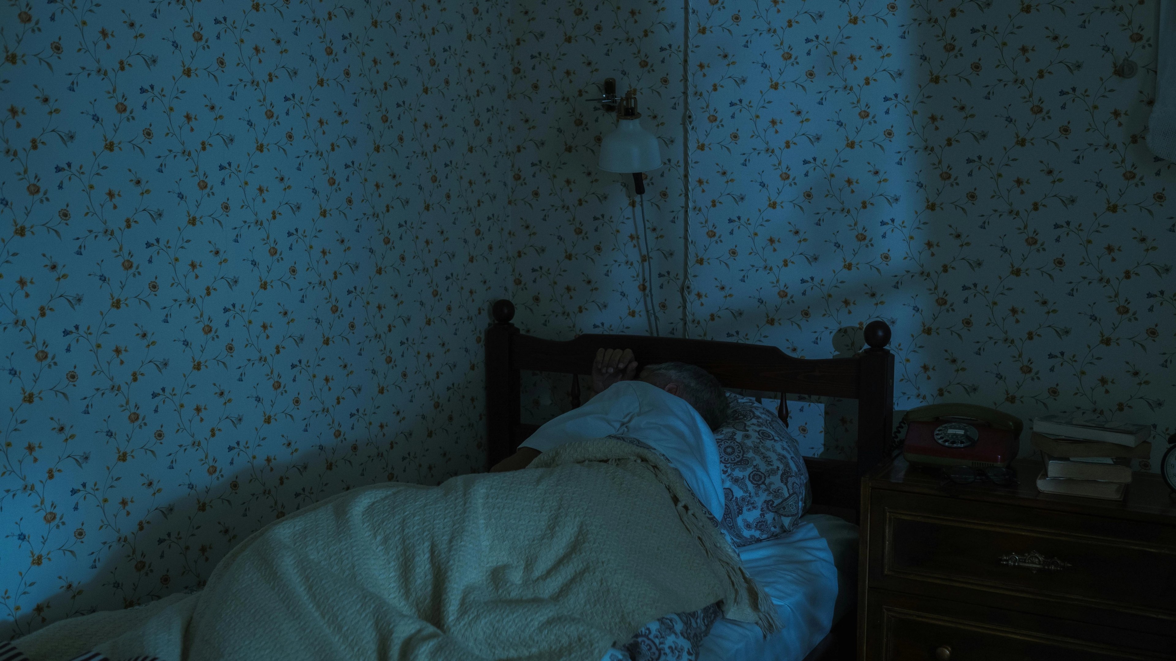 a person is sleeping in a bed in a dark room