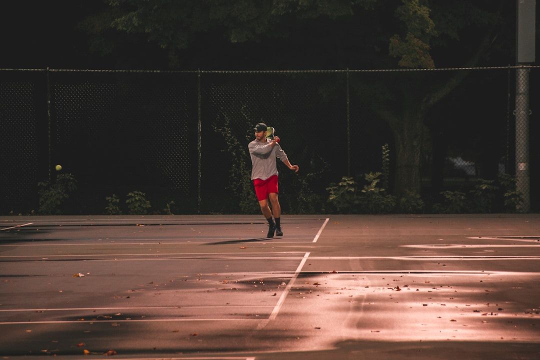 Man playing tennis at sunset in Milwaukee, WI. - Photo by Mike Cox on Unsplash