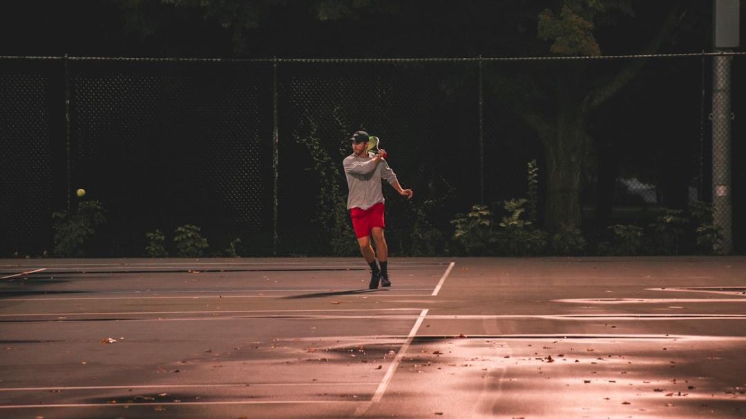 Man playing tennis at sunset in Milwaukee, WI. - Photo by Mike Cox on Unsplash