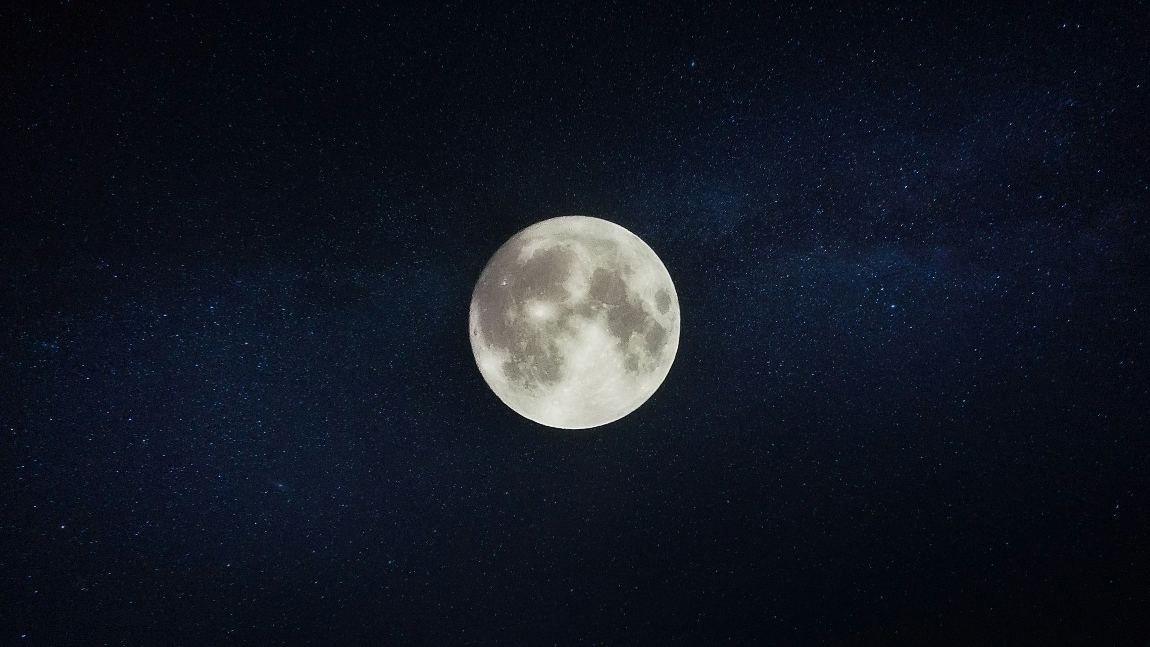 A full moon in a starry night sky