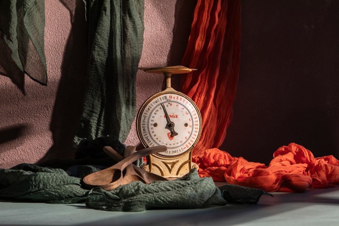 A vintage scale is posed with colorful fabrics. - Photo by Angelo Casto on Unsplash