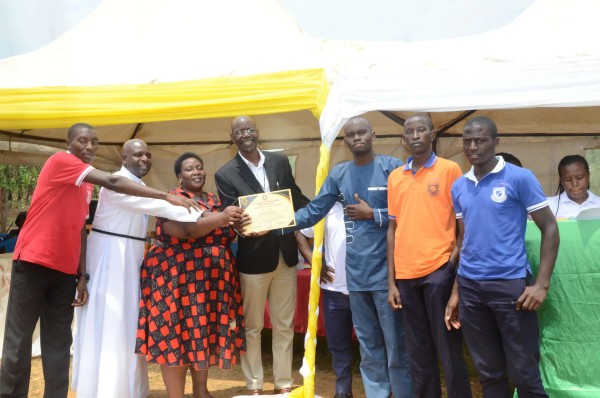 Overall champions receiving award with Headteacher Br. Gordian Twesigye at Chavoc Talent Show