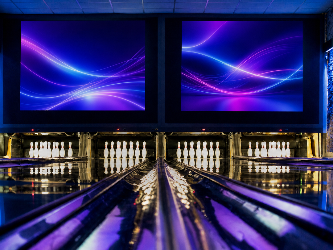 Vier Bowlingbahnen im blau-violett beleuchteten VIP-Bereich.