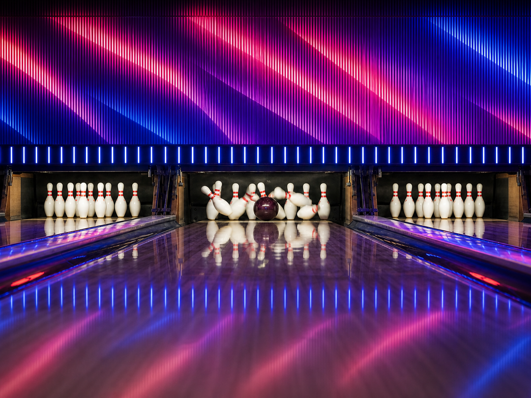 Eine Bowlingkugel trifft Pins vor einer rot-blau beleuchteten LED-Wand.