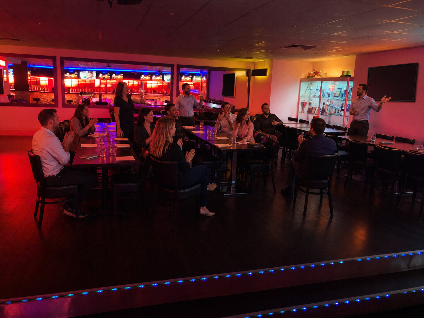 A group listens to a presentation in a lit event area.