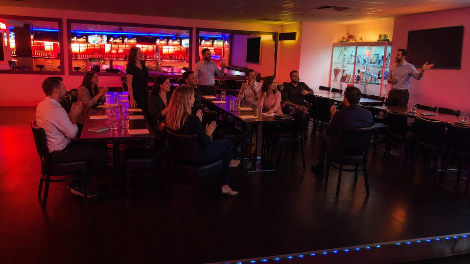 A group listens to a presentation in a lit event area.