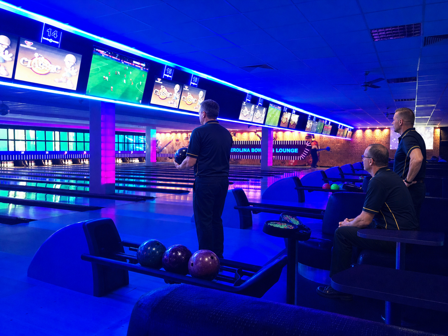 Three adult sport bowlers prepare for their game beside the lanes.