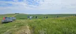 The Riverside team walking through a green field under a cloudy sky