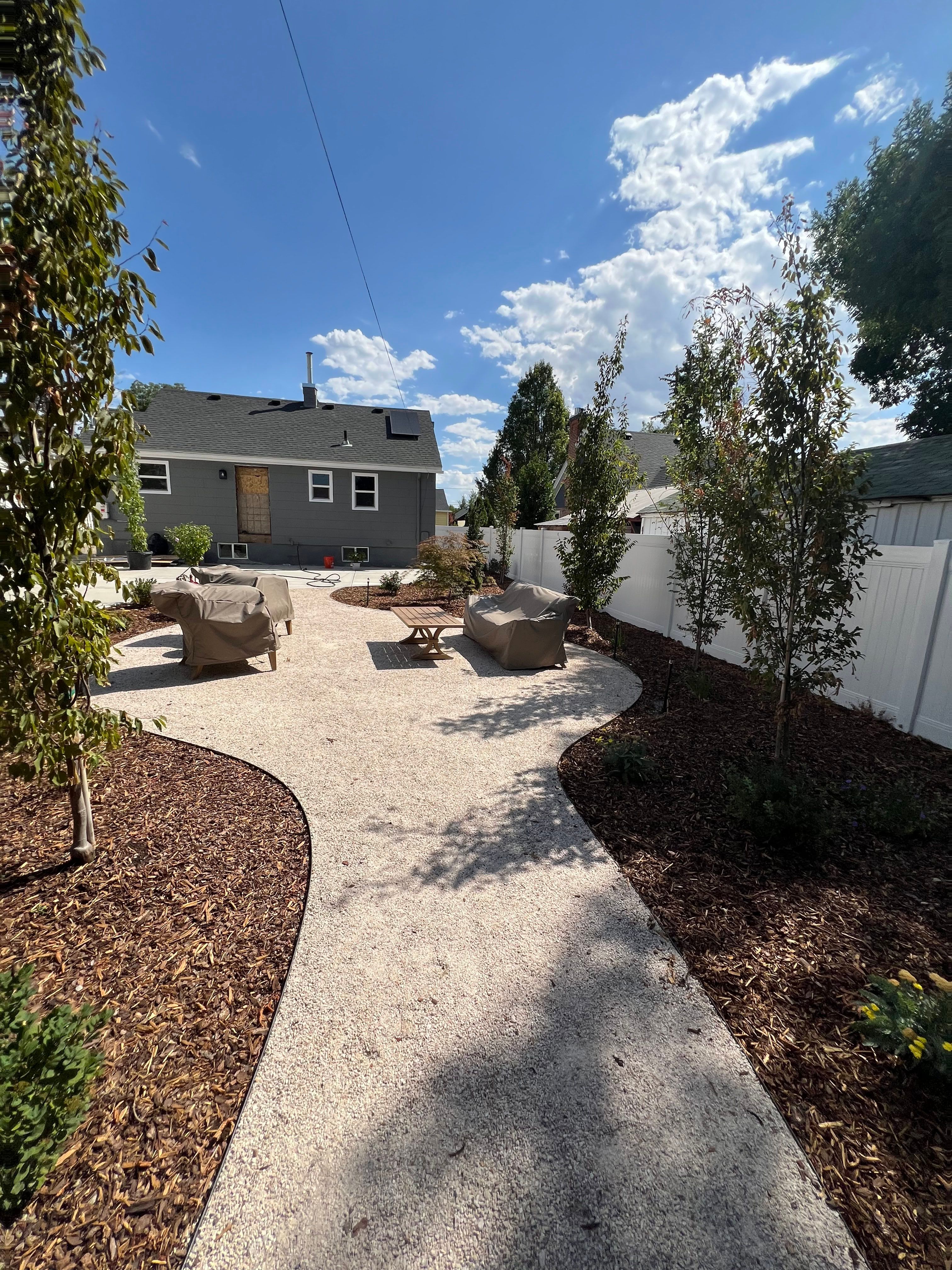 Alternate view of xeriscape walkway in Millcreek with drought-tolerant plants and bark mulch.
