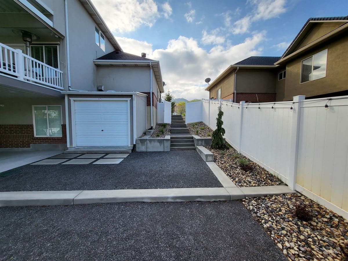 Bountiful backyard with concrete retaining walls, paver steps, and a chat patio area.