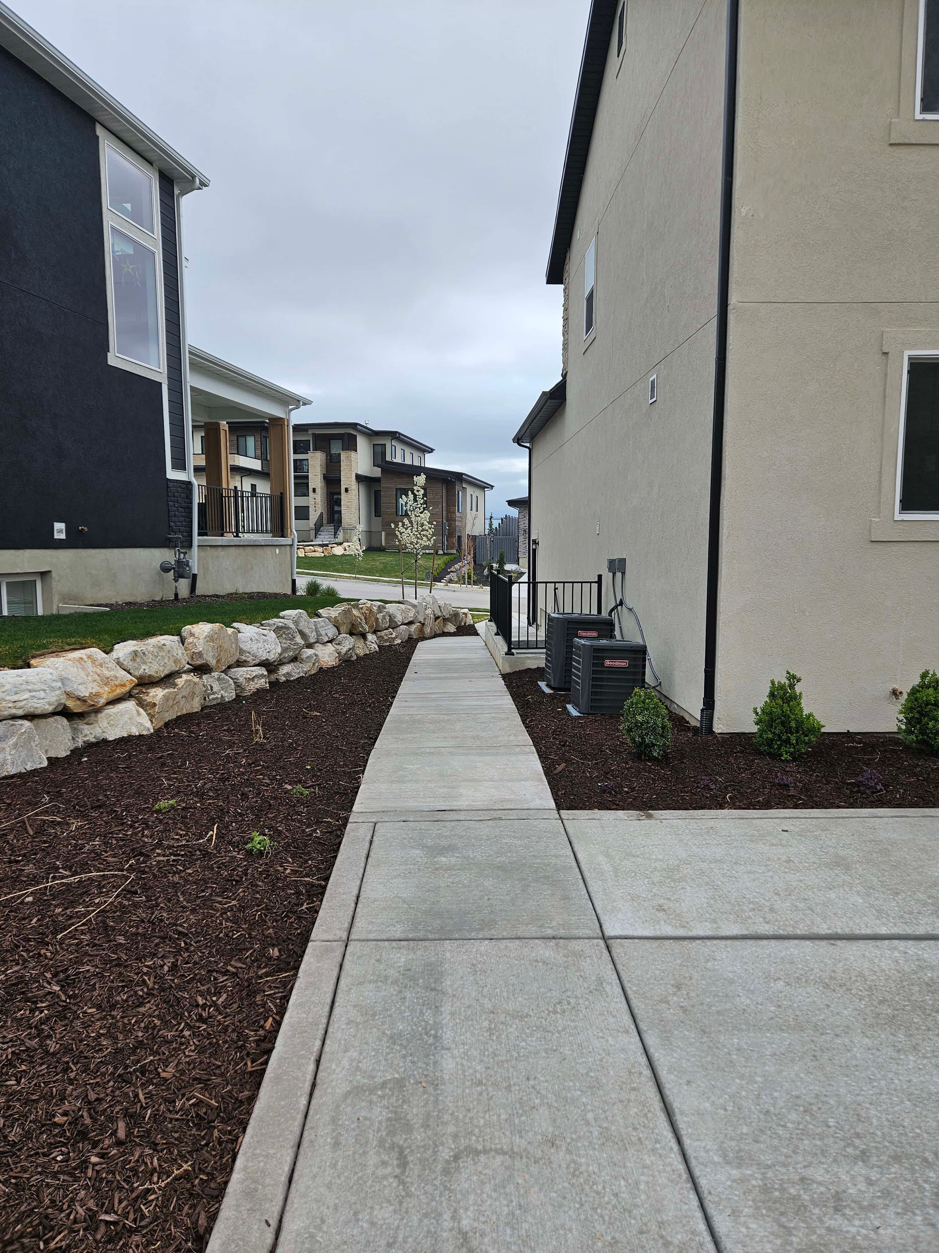 Concrete walkway leading to the front yard in Lehi, Utah landscape project.