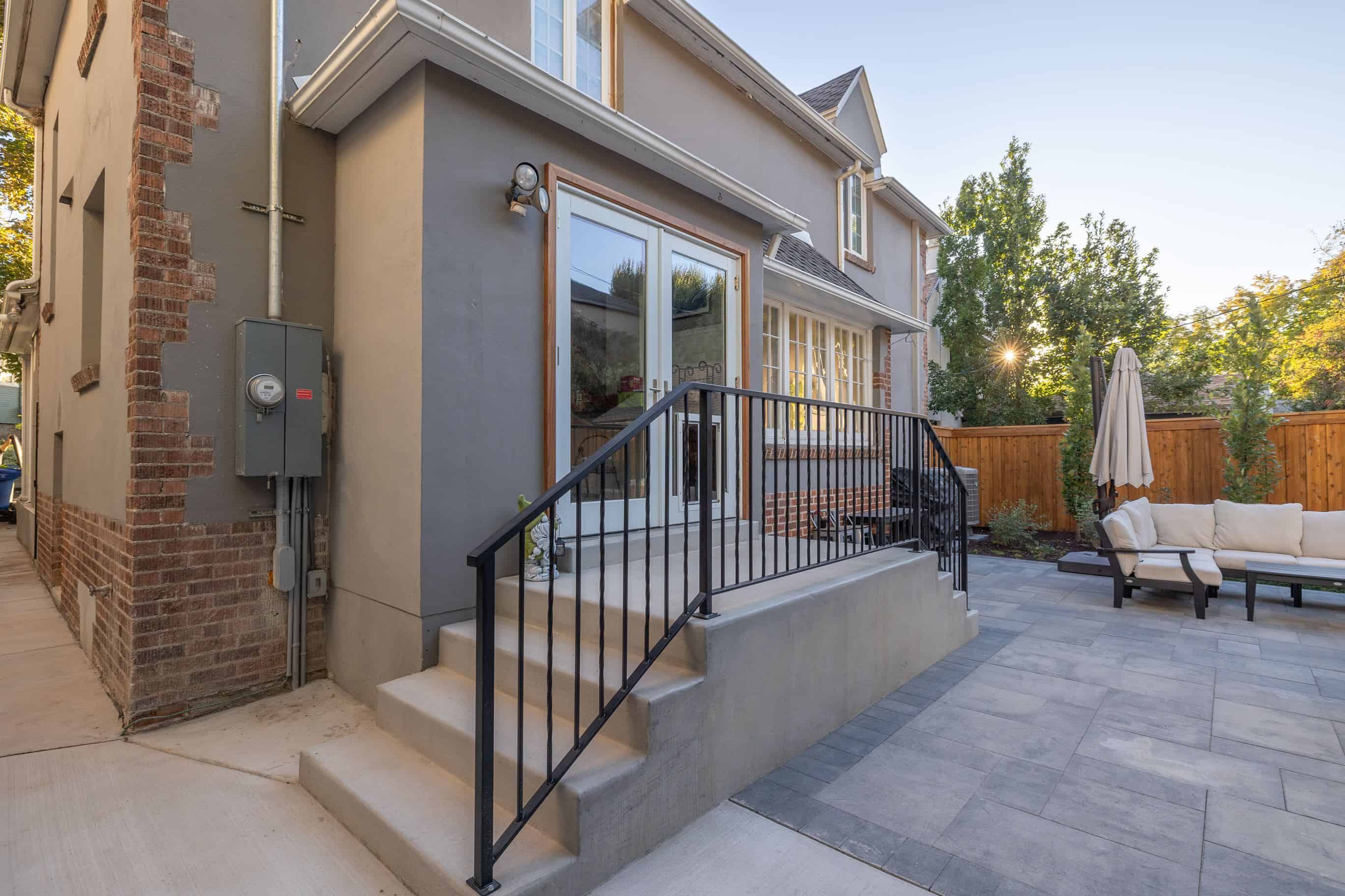 Pavers patio installation with concrete stairs and metal railing in Federal Heights, Utah.