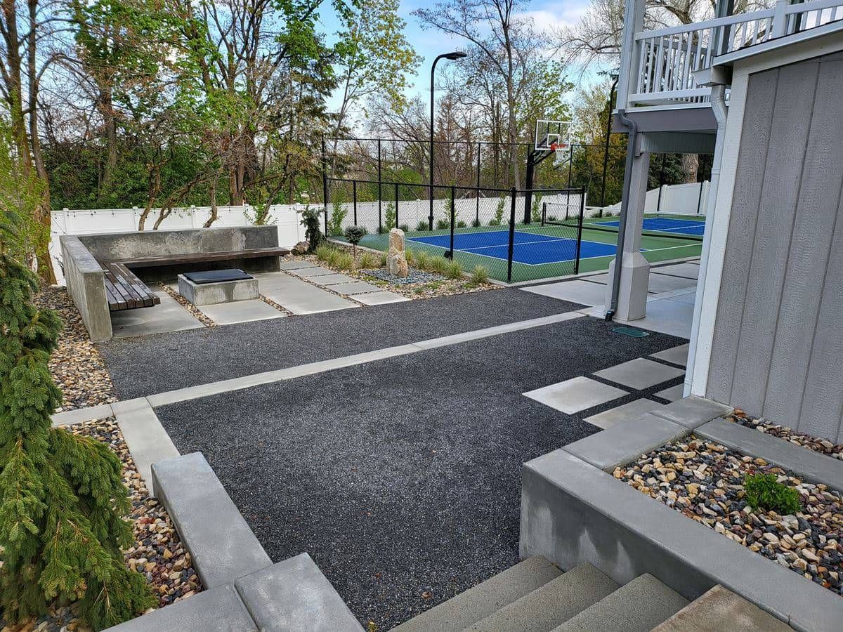 Modern outdoor fire pit patio in Bountiful with concrete hardscape and surrounding seating.