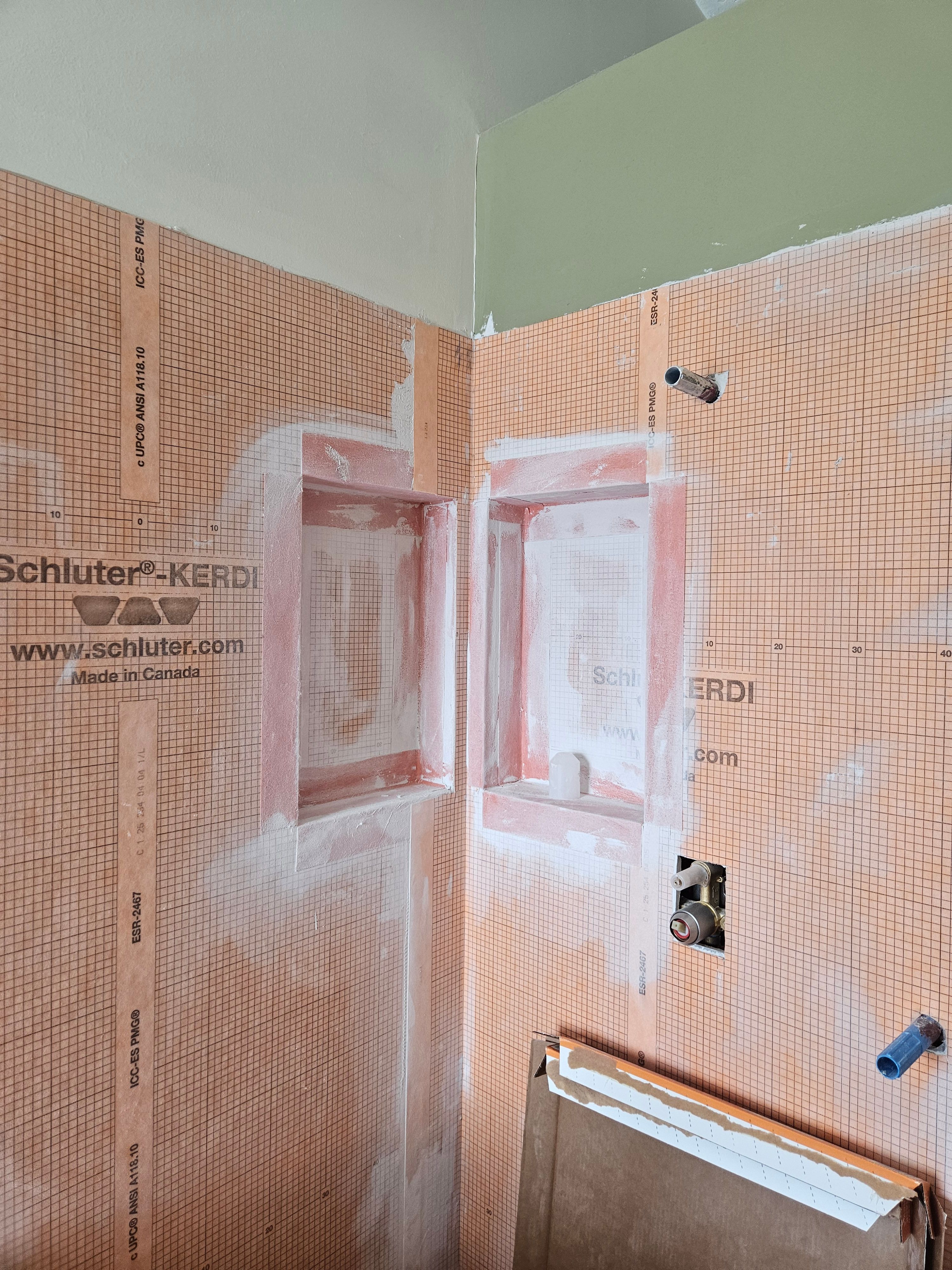 Shower niches highlighted during bathroom remodel in Murray, Utah with waterproofing and tile prep visible.