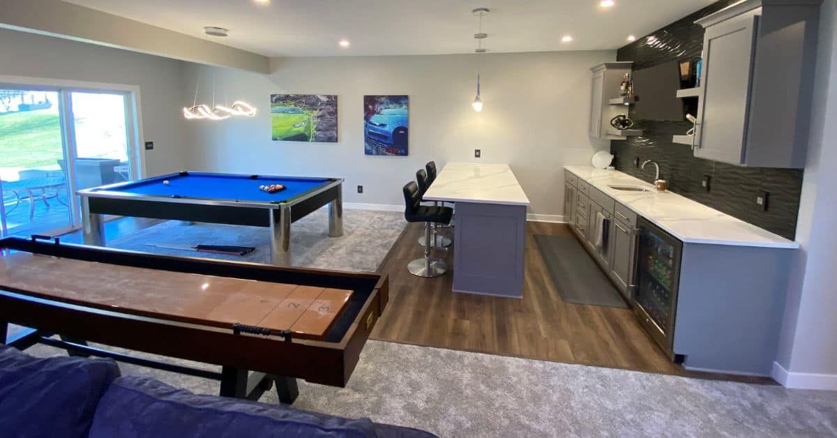 Custom basement game room with a pool table and built-in entertainment center in Lehi, Utah, designed by Pitt Landscape & Construction.