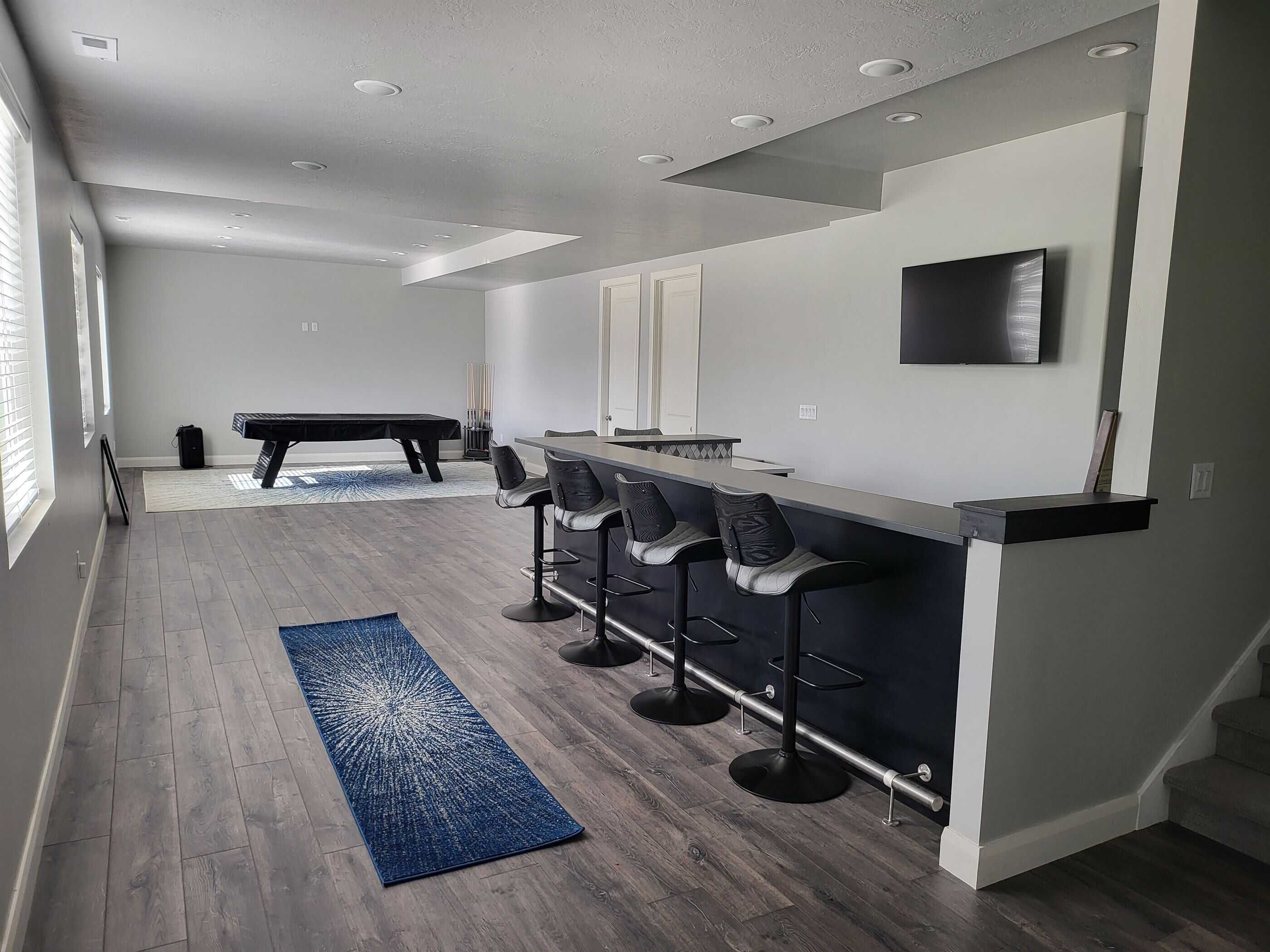 Custom basement bar with bar seats and flooring in a basement finishing project in Salt Lake City.