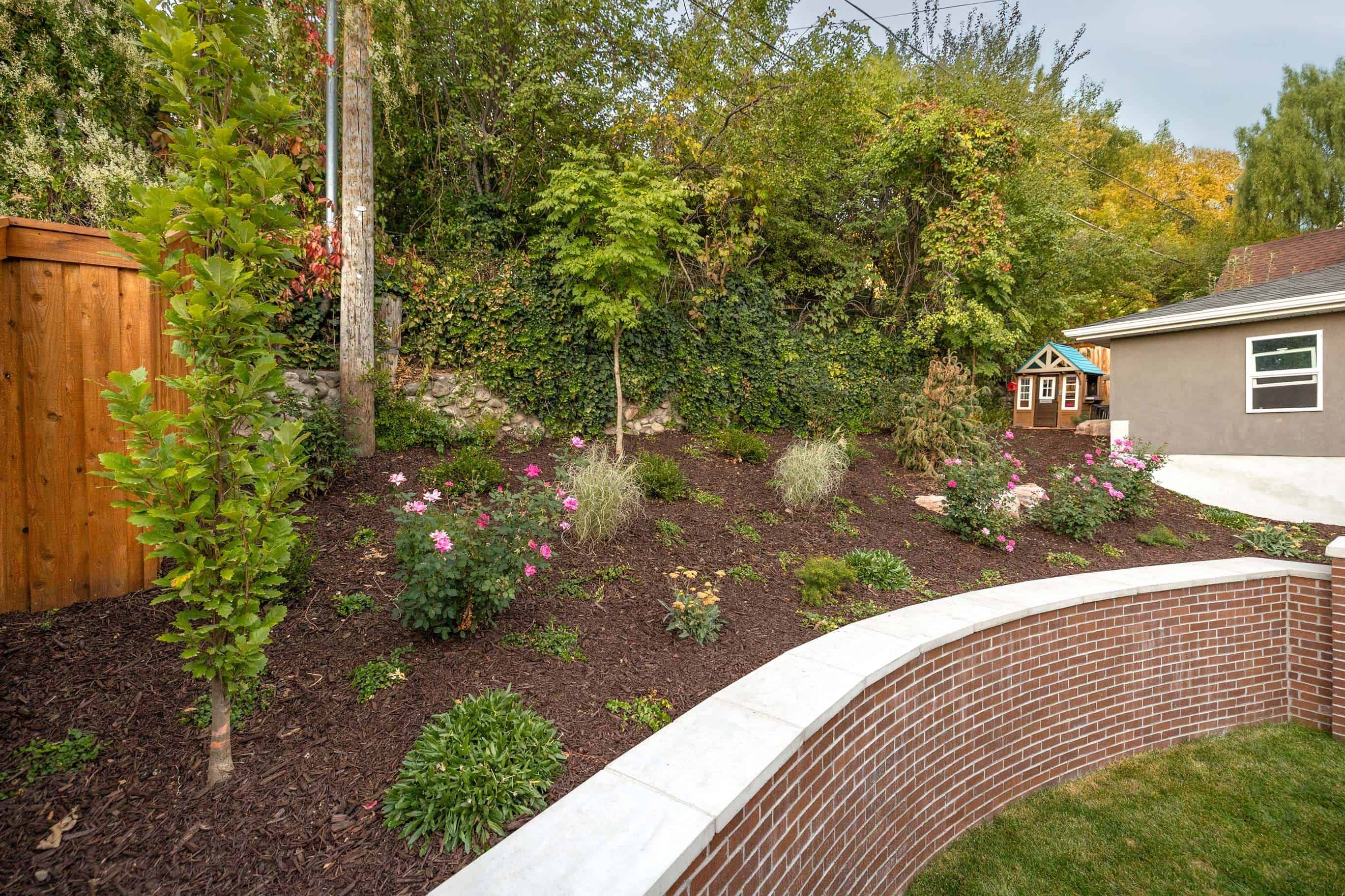 Close-up of a custom retaining wall with vibrant plants in a Salt Lake City landscape design.