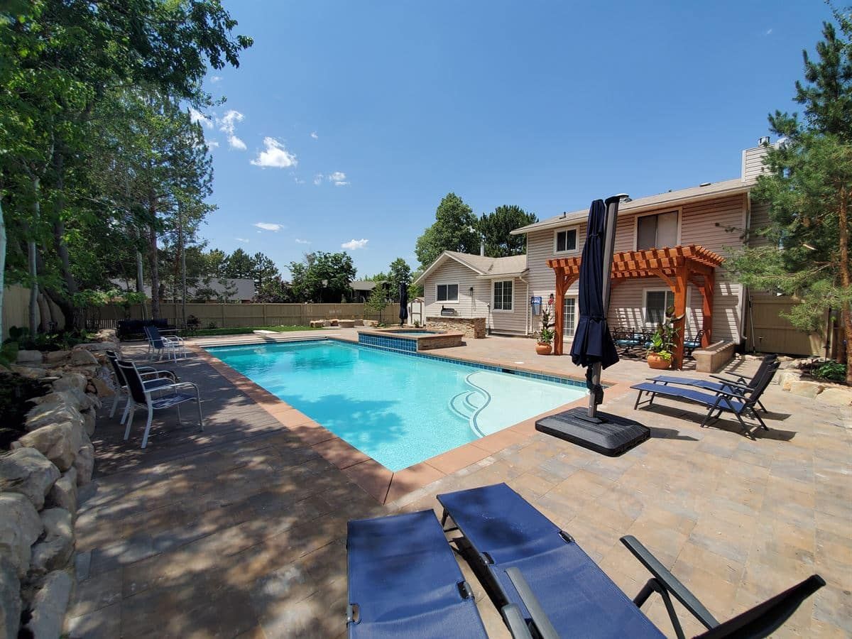 Outdoor space with pool and chairs outside the house