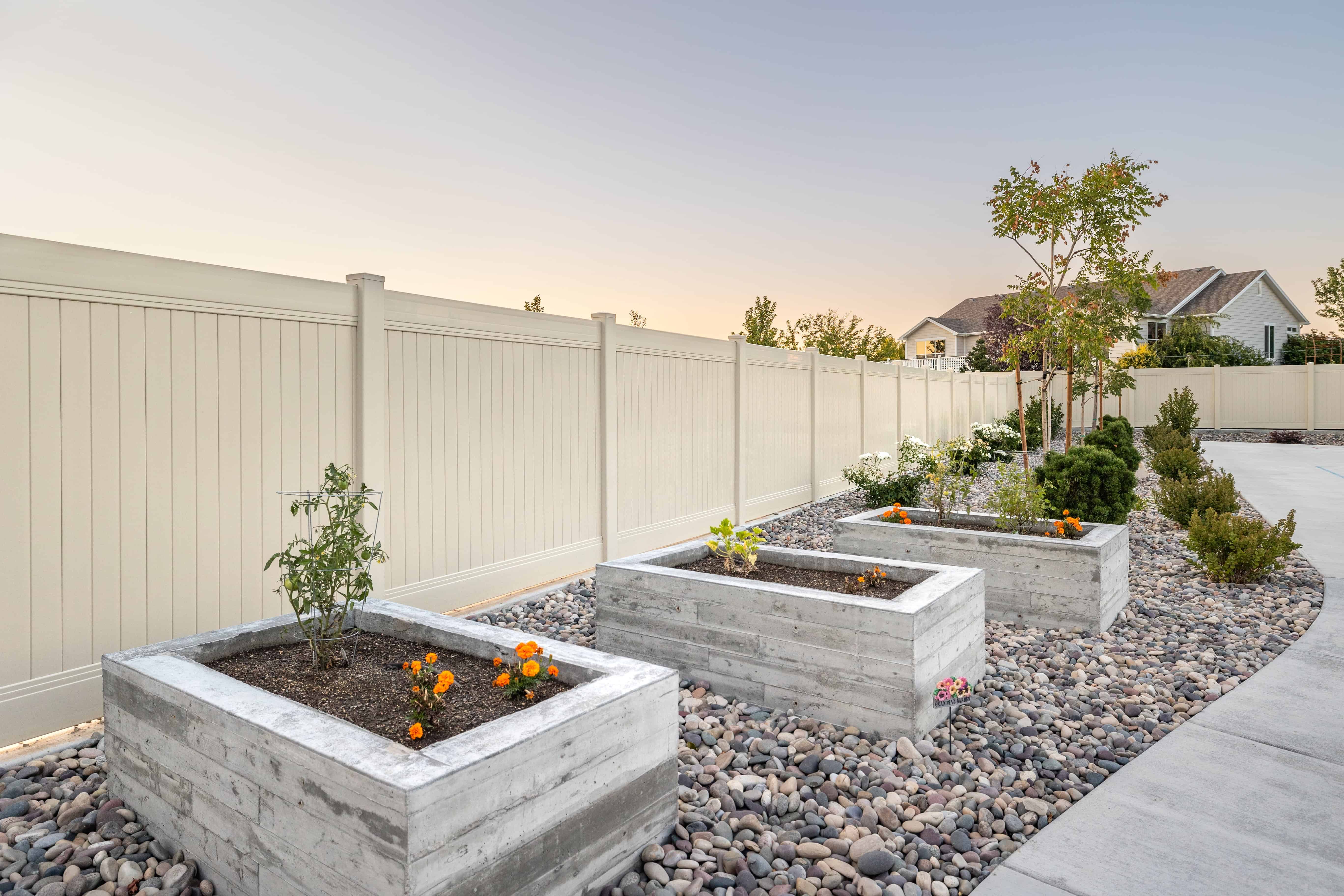 A front yard with paver planters, gravel, and concrete xeriscaping in Lehi.