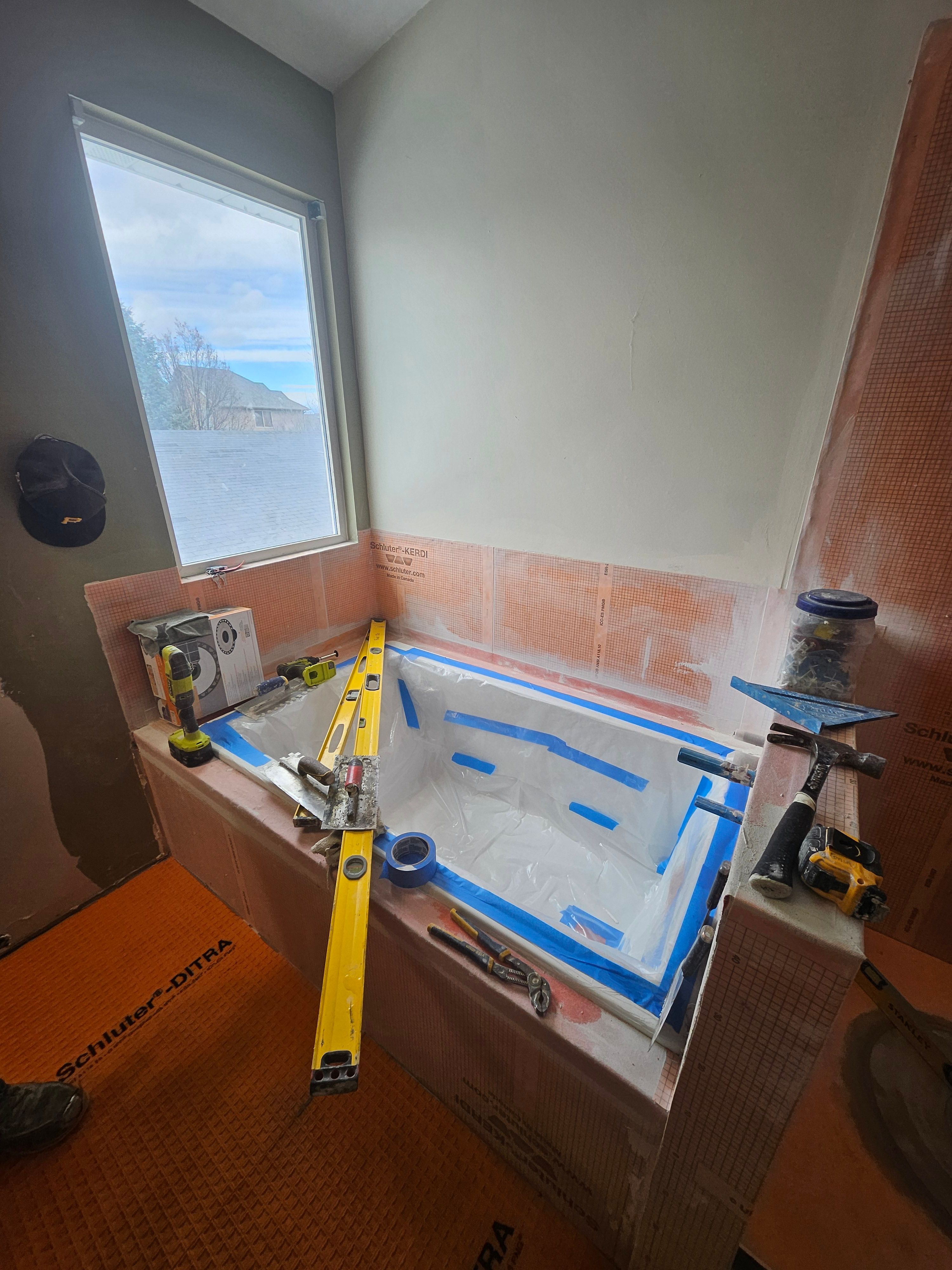 Tub surround waterproofing in progress during bathroom remodel in Murray, Utah.