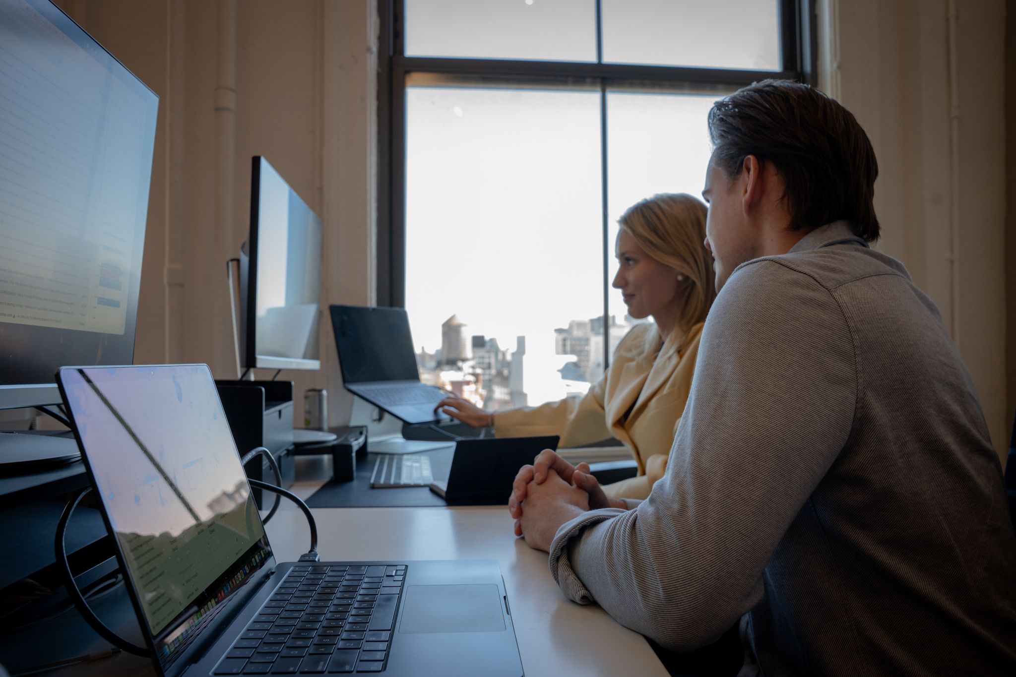 Two Avallon teammates reviewing work by the office window