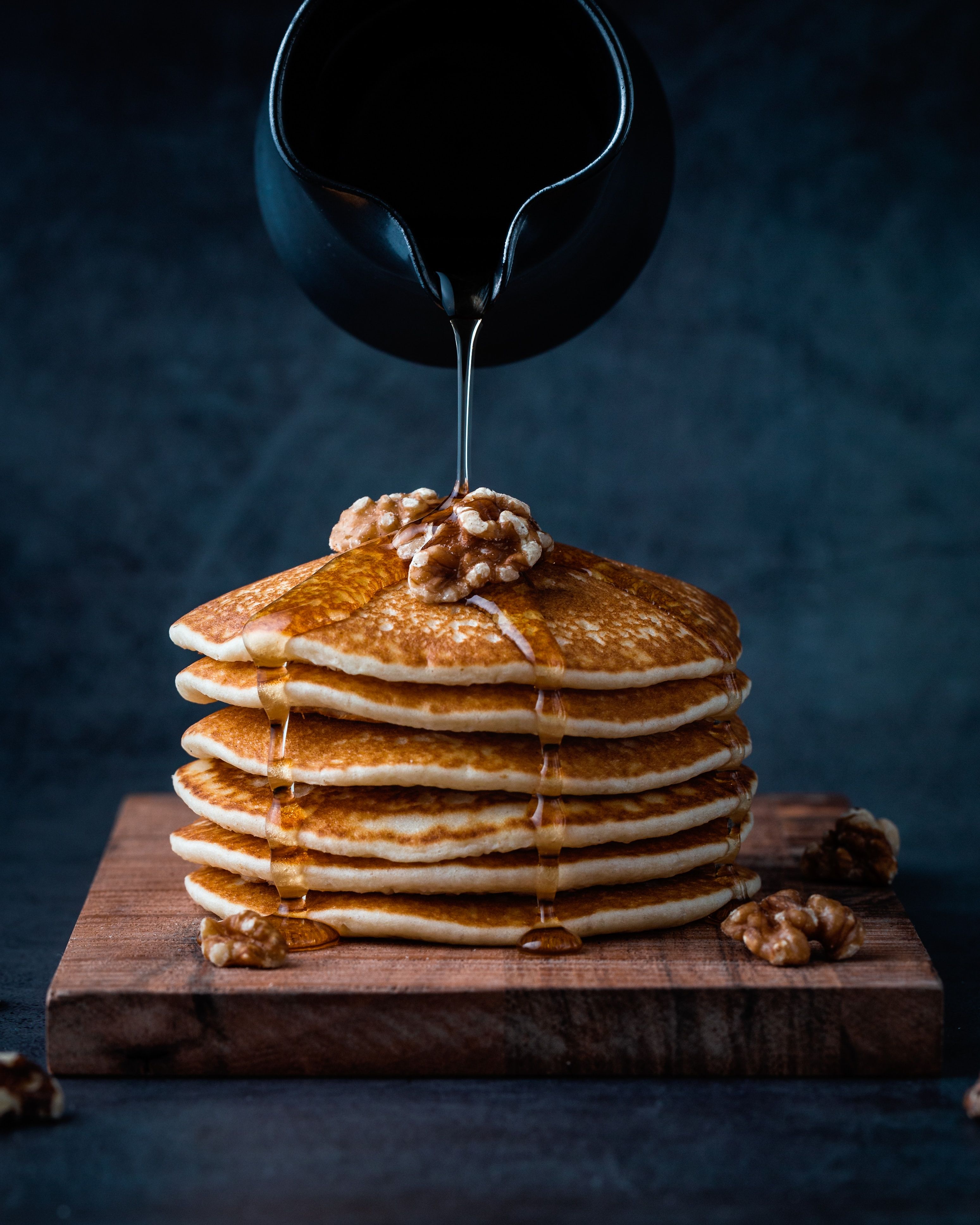 Maple syrup being poured onto Oat Banana pancakes