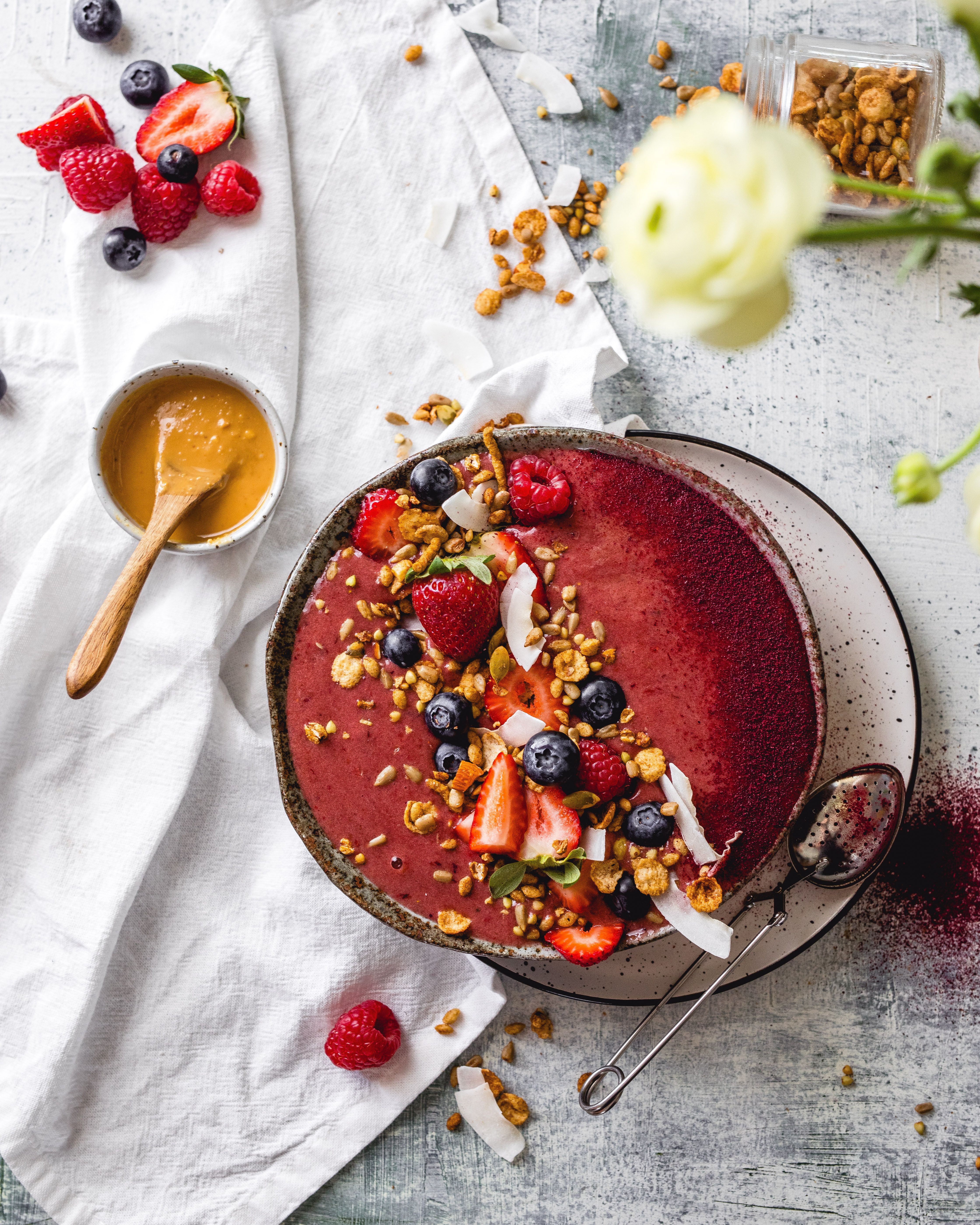 Plum Smoothie Bowl on a table with fresh fruit alongside