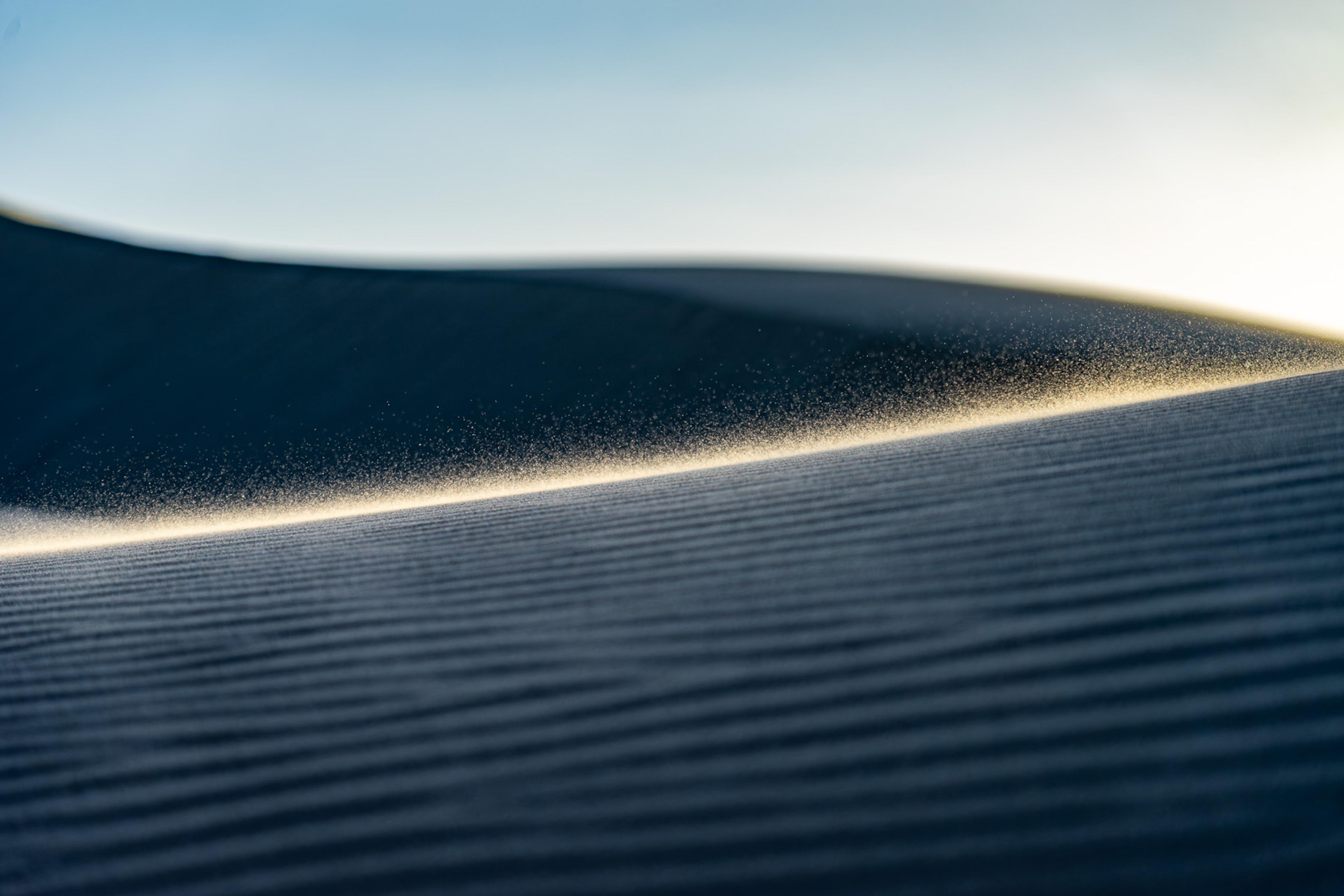 A dune crest in the Oceano dunes at last light, the curved ridge separating a luminous sky from the slope's deep shadow. Minimal and exact - two colours, one line, and the quality of light that only lasts minutes.