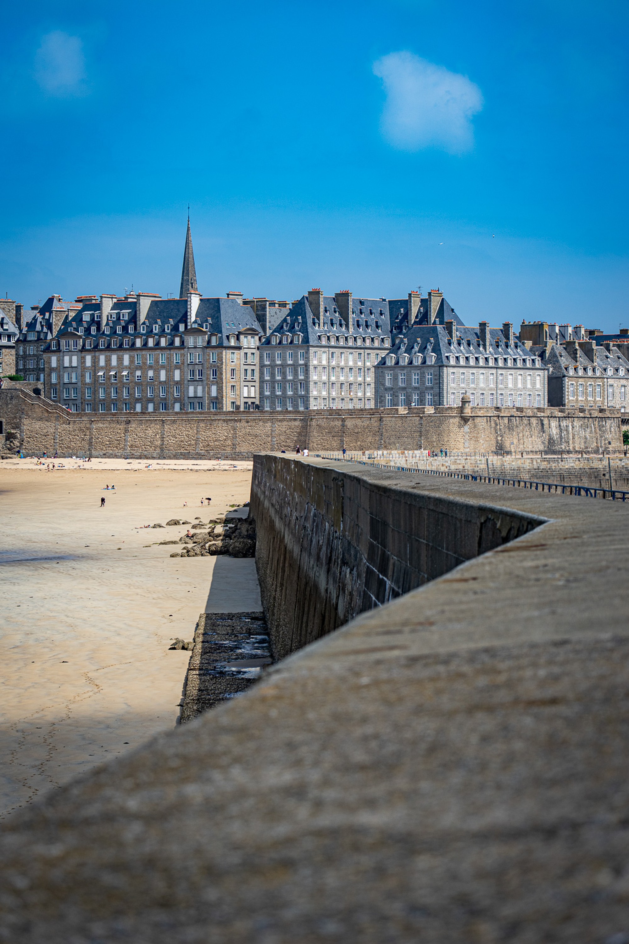 The ancient ramparts of Saint-Malo trace a clean horizontal line between beach and sky. Shot at low tide, the walled city sits dense and composed above an expanse of empty sand - a view that rewards a large format.