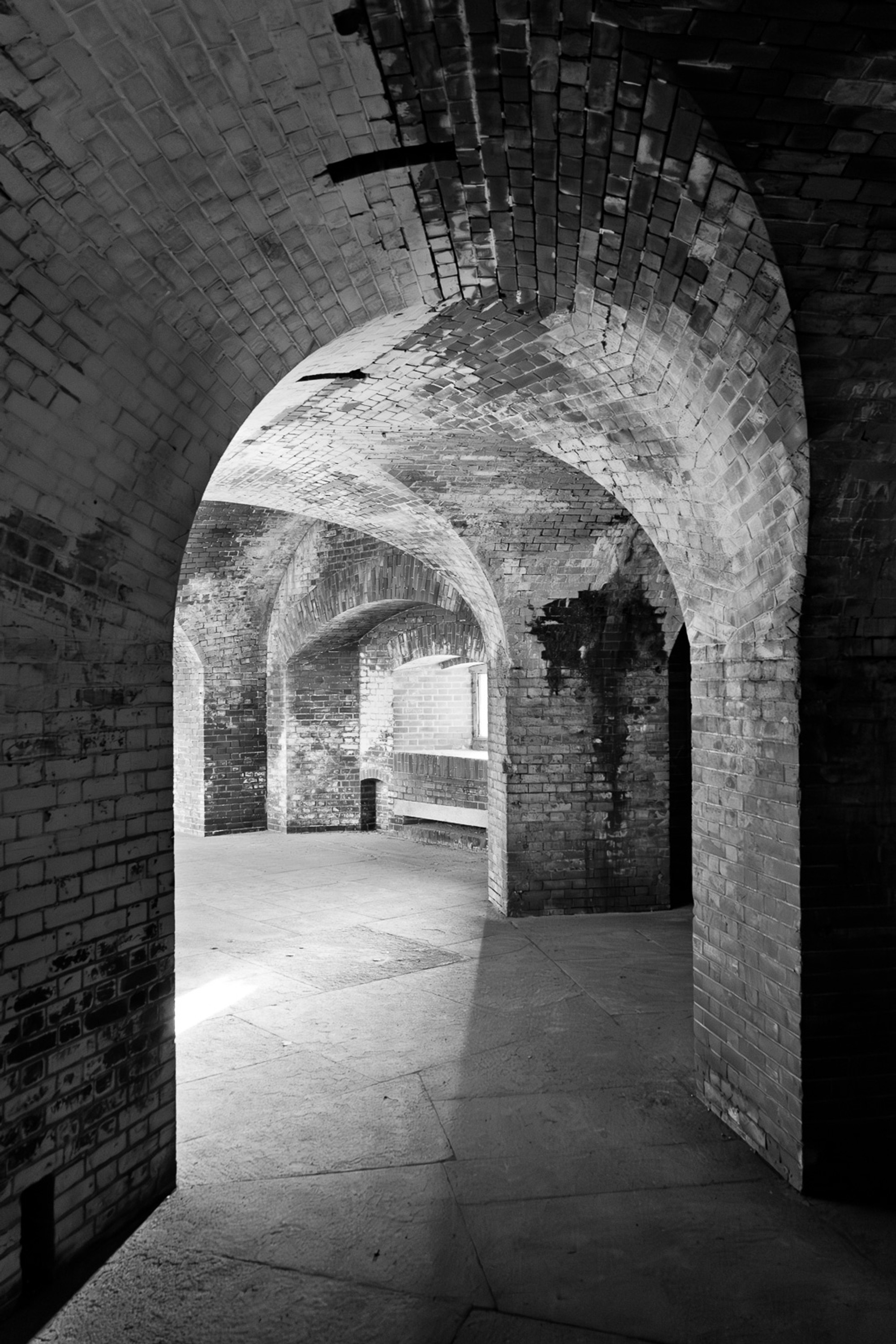 The brick-vaulted corridors of Fort Point in black and white, the Civil War-era arches repeating in perspective down the passageway. A fortress built to last, directly beneath a bridge that didn't exist yet.