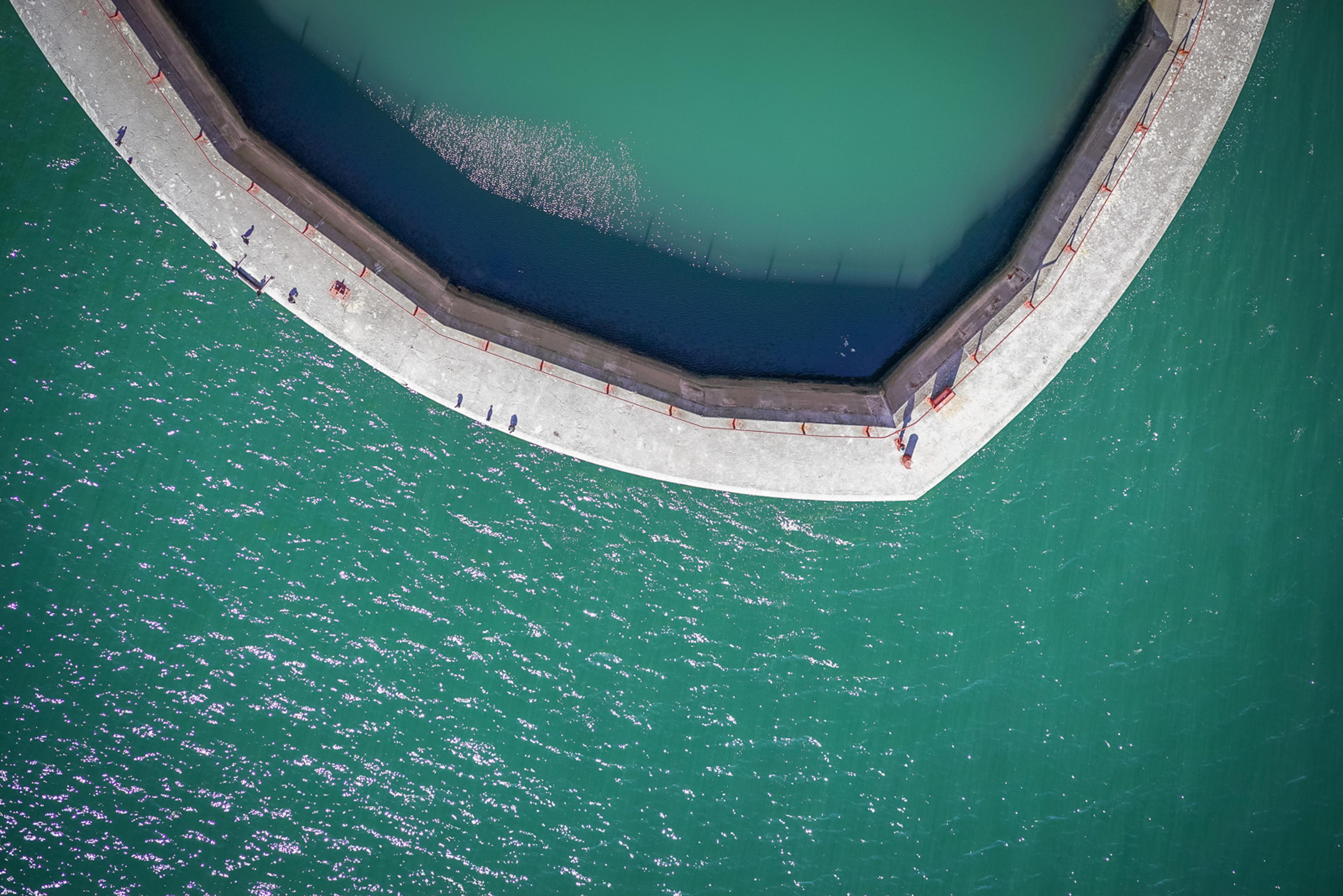 The basin of the Golden Gate Bridge's north tower from directly above, concrete shell to safeguard the massive red structure rising straight up.