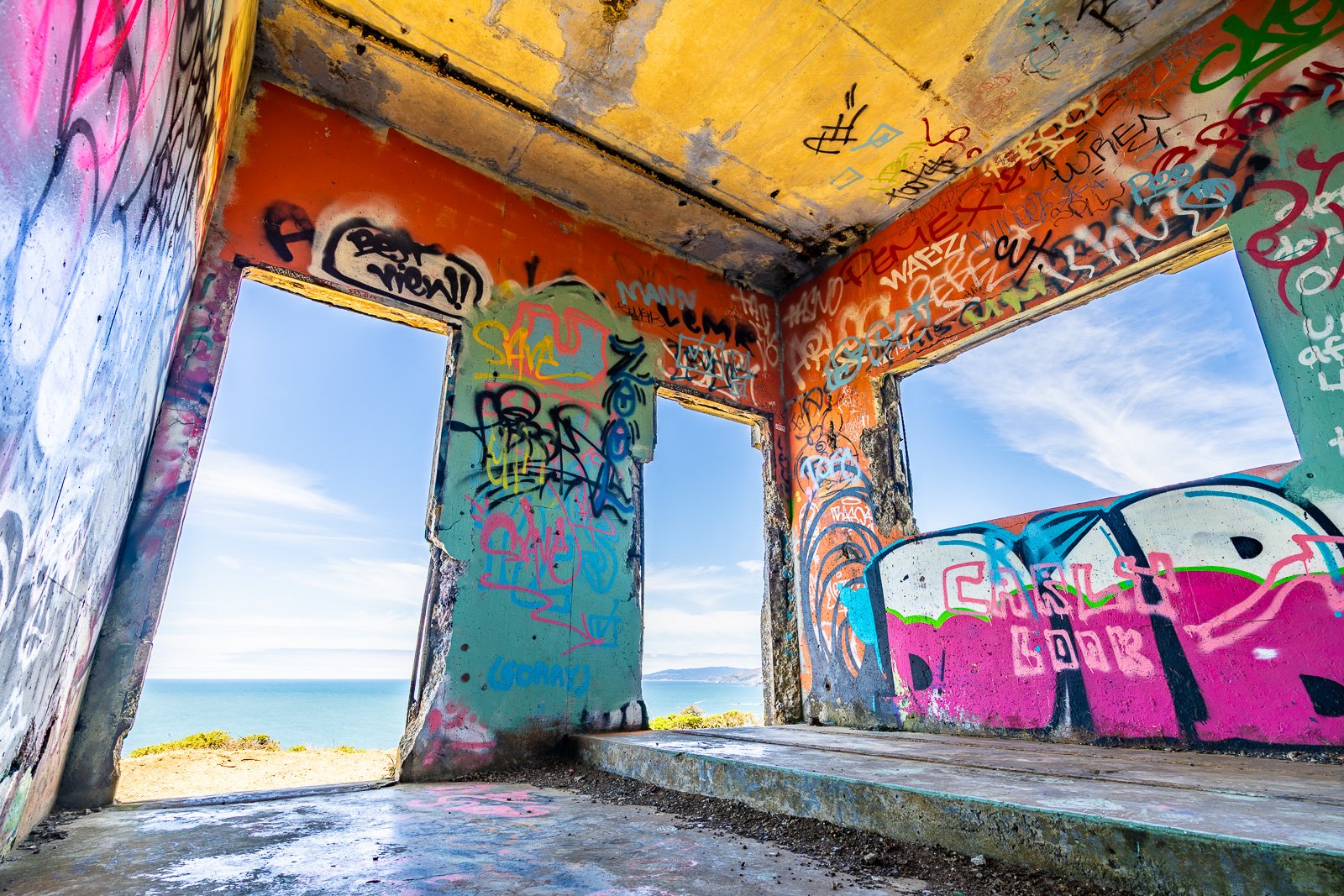 A derelict graffiti-covered room on the Marin Headlands, its far wall open to an unobstructed view of the Pacific. The coloured murals and broken concrete frame the ocean - a room that has become a viewfinder.