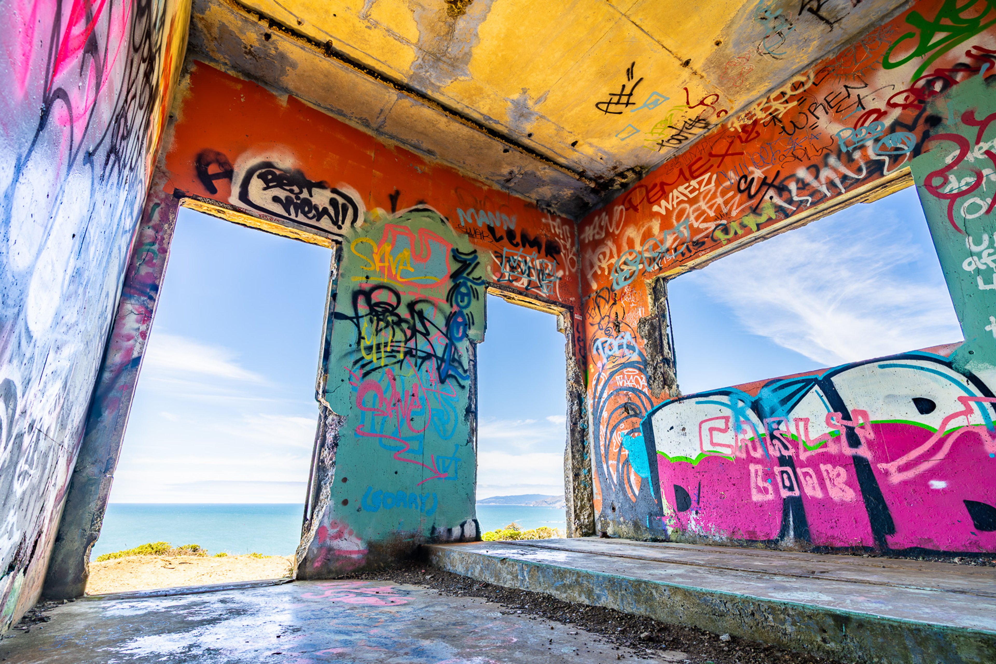 A derelict graffiti-covered room on the Marin Headlands, its far wall open to an unobstructed view of the Pacific. The coloured murals and broken concrete frame the ocean - a room that has become a viewfinder.